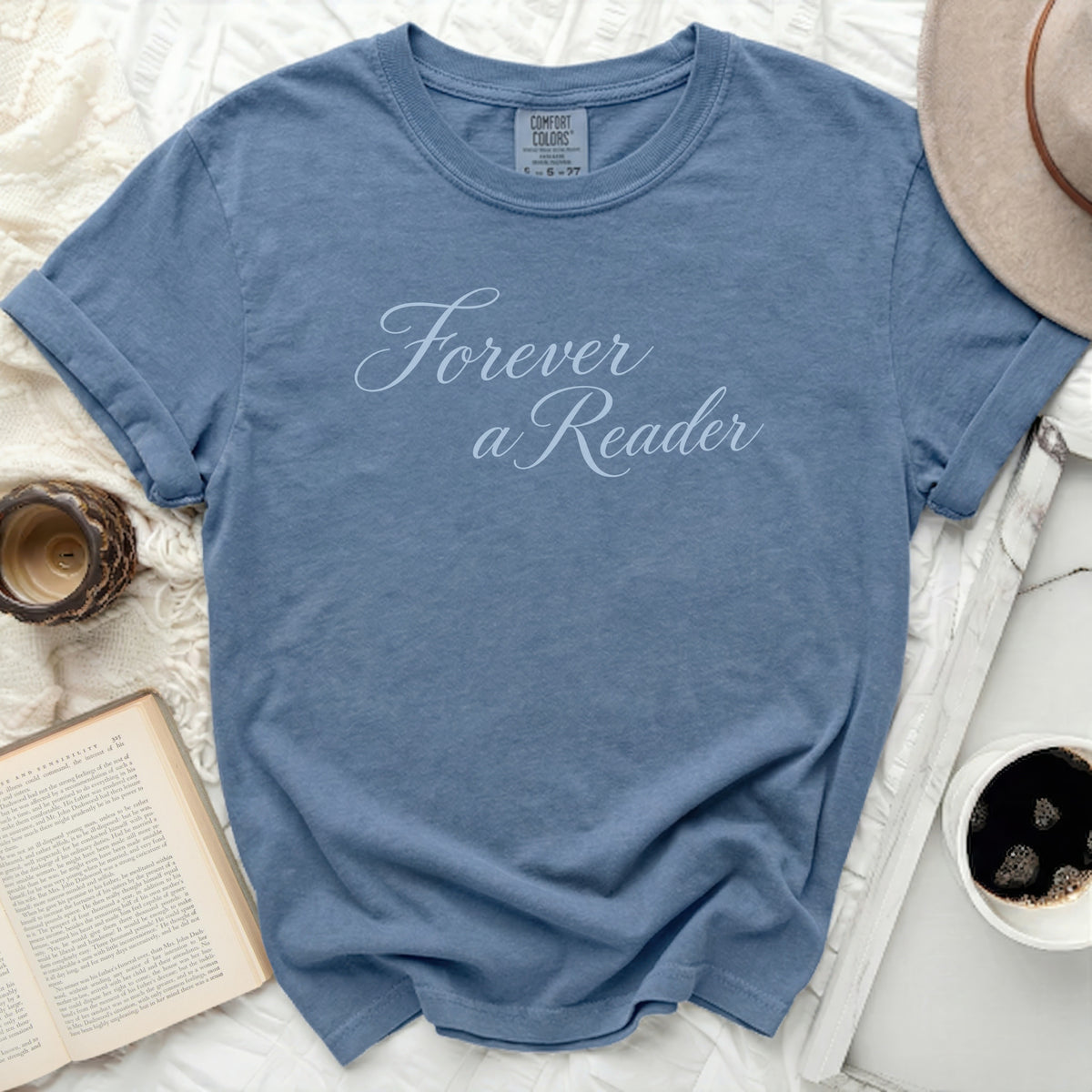 Blue t-shirt with "Forever a Reader" text, book, and hat.
