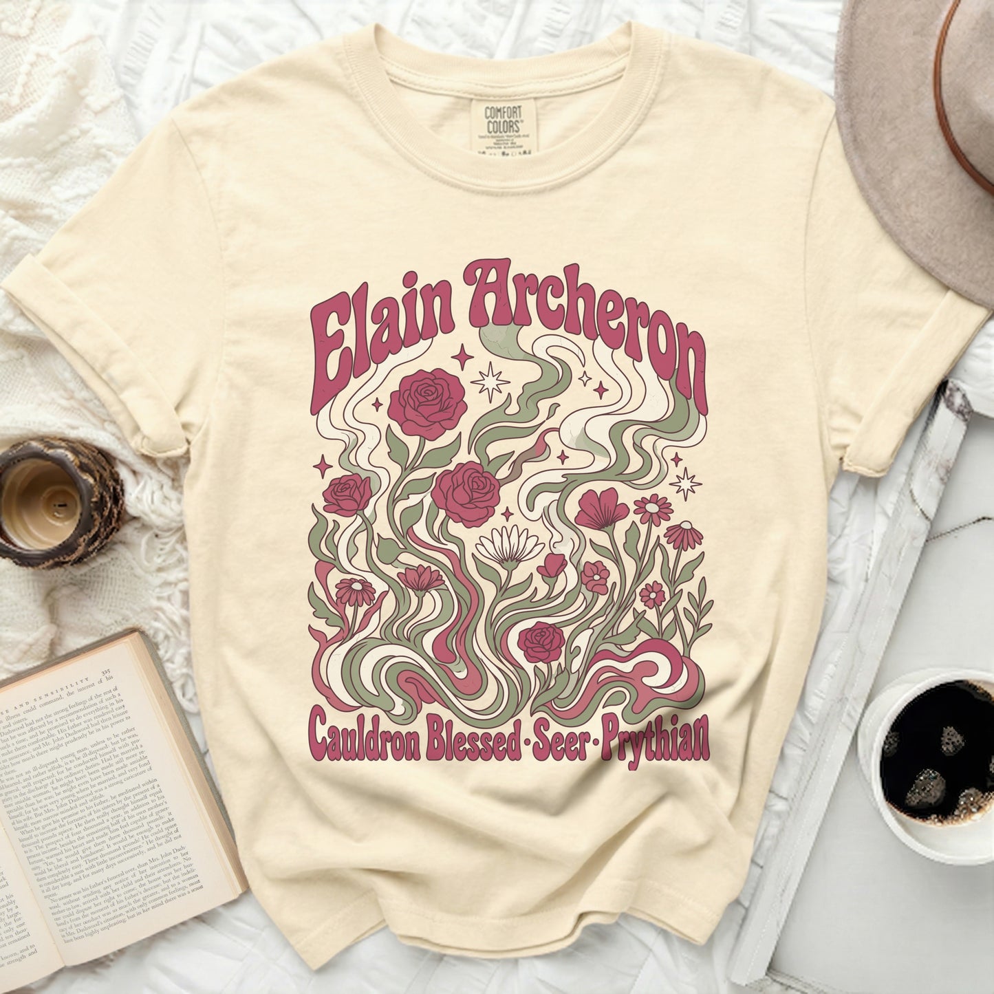 Cream t-shirt with "Elain Archeron Cauldron Blessed Seer Prythian" floral design.