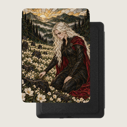 A woman with blonde hair in a black outfit and red cape kneels in a field of white flowers.