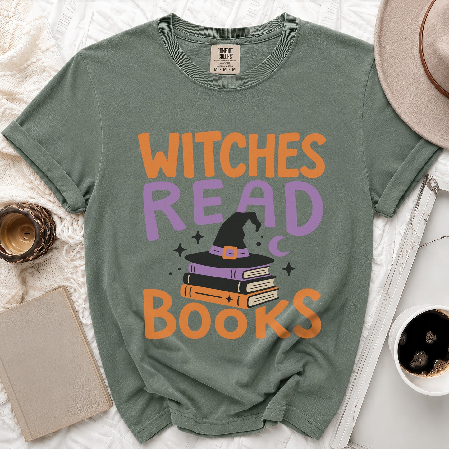 Green t-shirt with "Witches Read Books" text and witch hat on books graphic.
