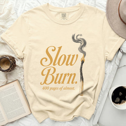 Cream t-shirt with "Slow Burn. 400 pages of almost." text and burnt match.