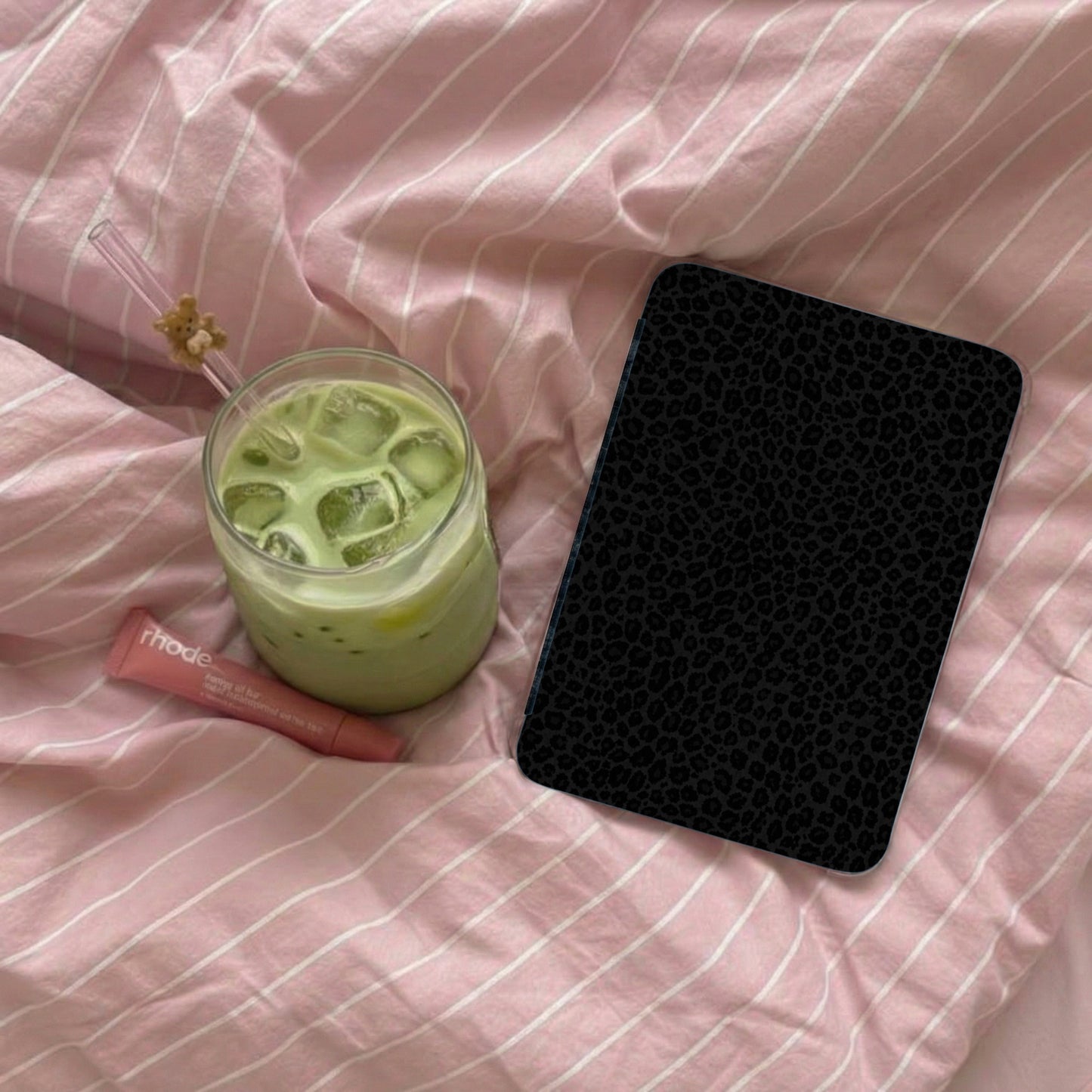 Black leopard print phone case with a matcha latte and lip balm.