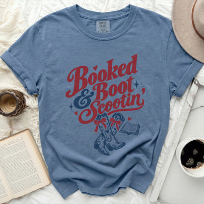 Blue t-shirt with "Booked & Boot Scootin" graphic featuring cowboy boots and a book.