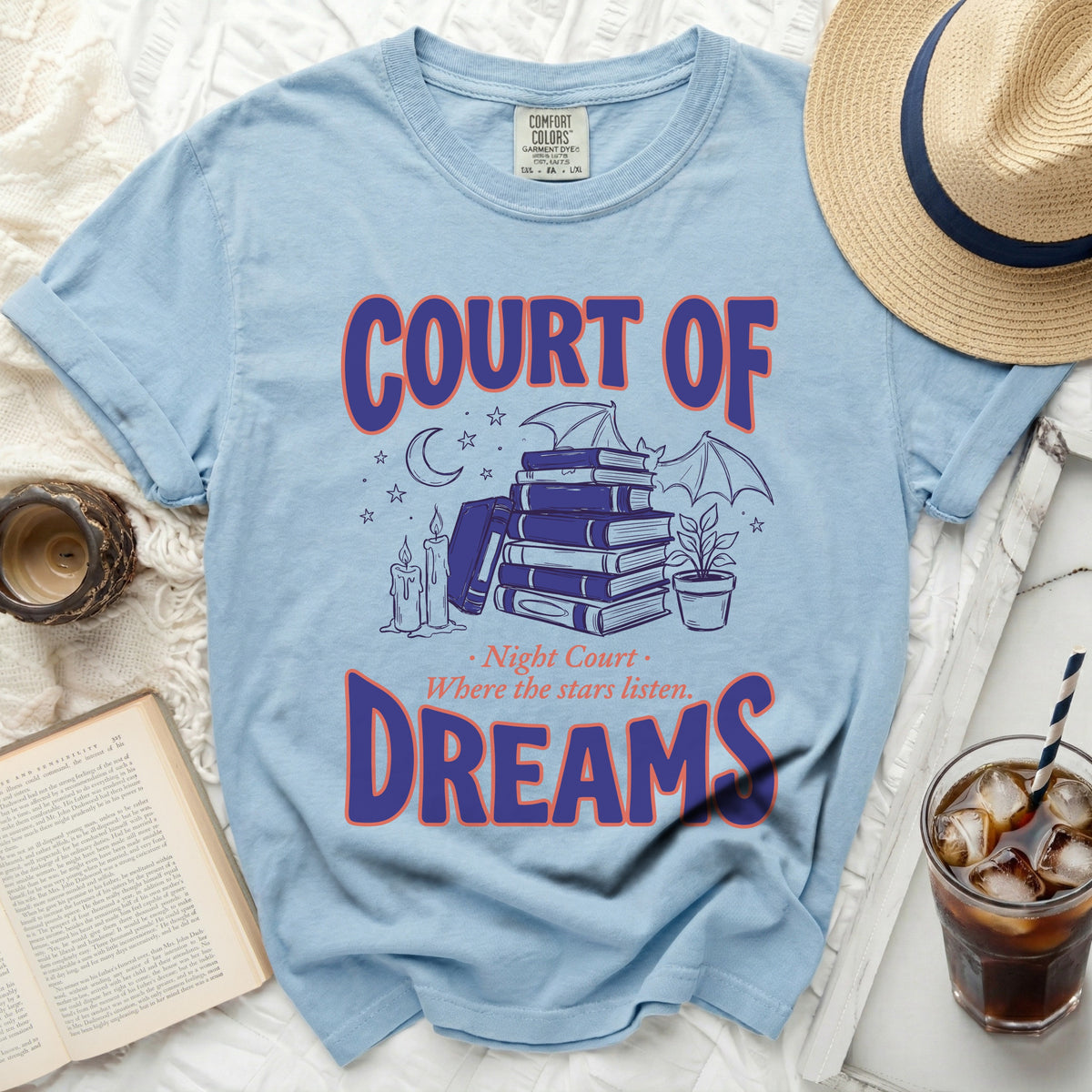 Light blue t-shirt with "COURT OF DREAMS" and a drawing of books, candles, and a bat.