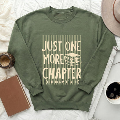 Green sweatshirt with "Just One More Chapter" text and book graphic.