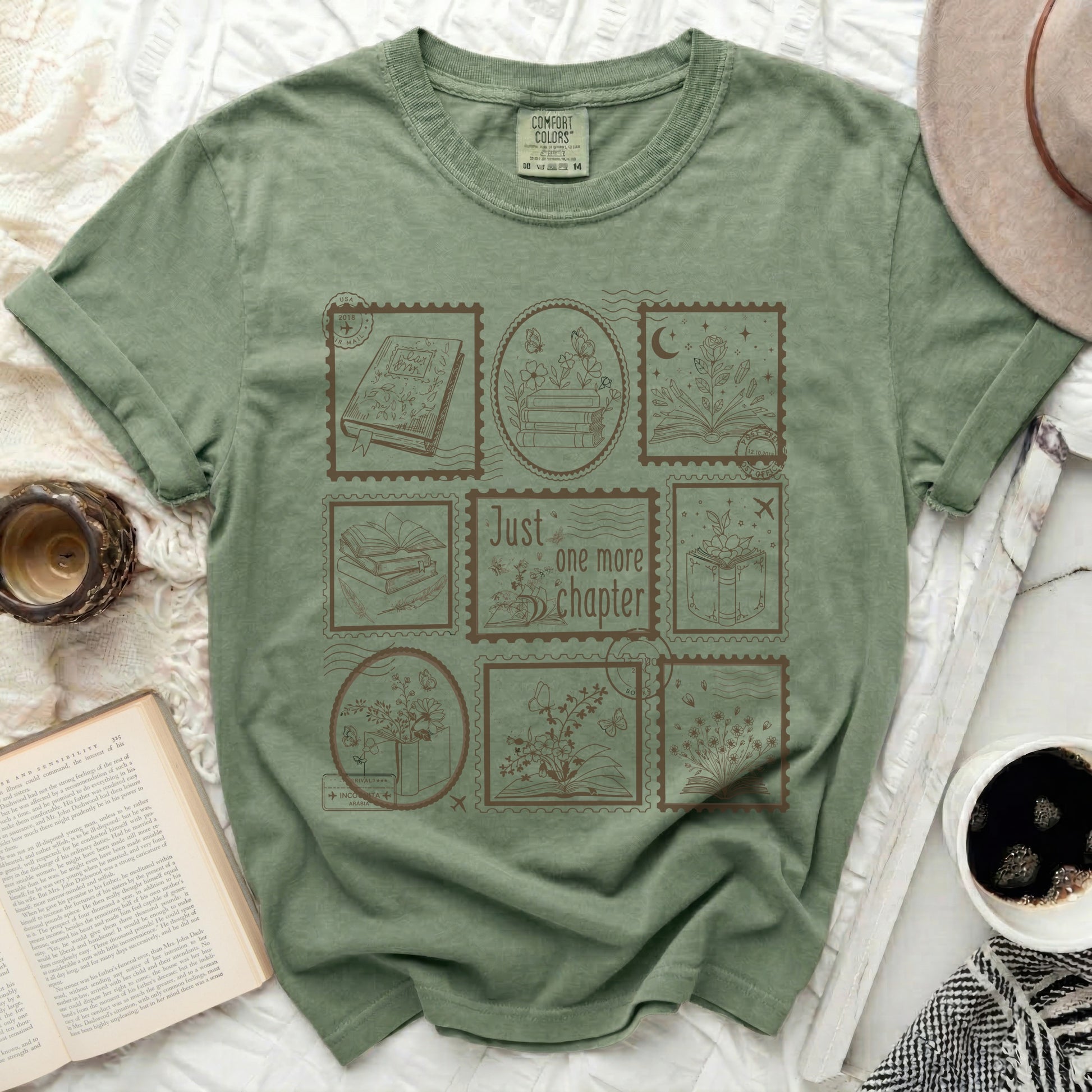 Green t-shirt with a postage stamp design featuring books, flowers, and the text "Just one more chapter".