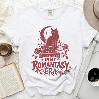 White t-shirt with a dark red graphic of a cat on books, moon, and roses. Text reads "In My Romantasy Era".
