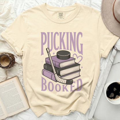 T-shirt with stacked books, hockey stick, and puck, saying "Pucking Booked".