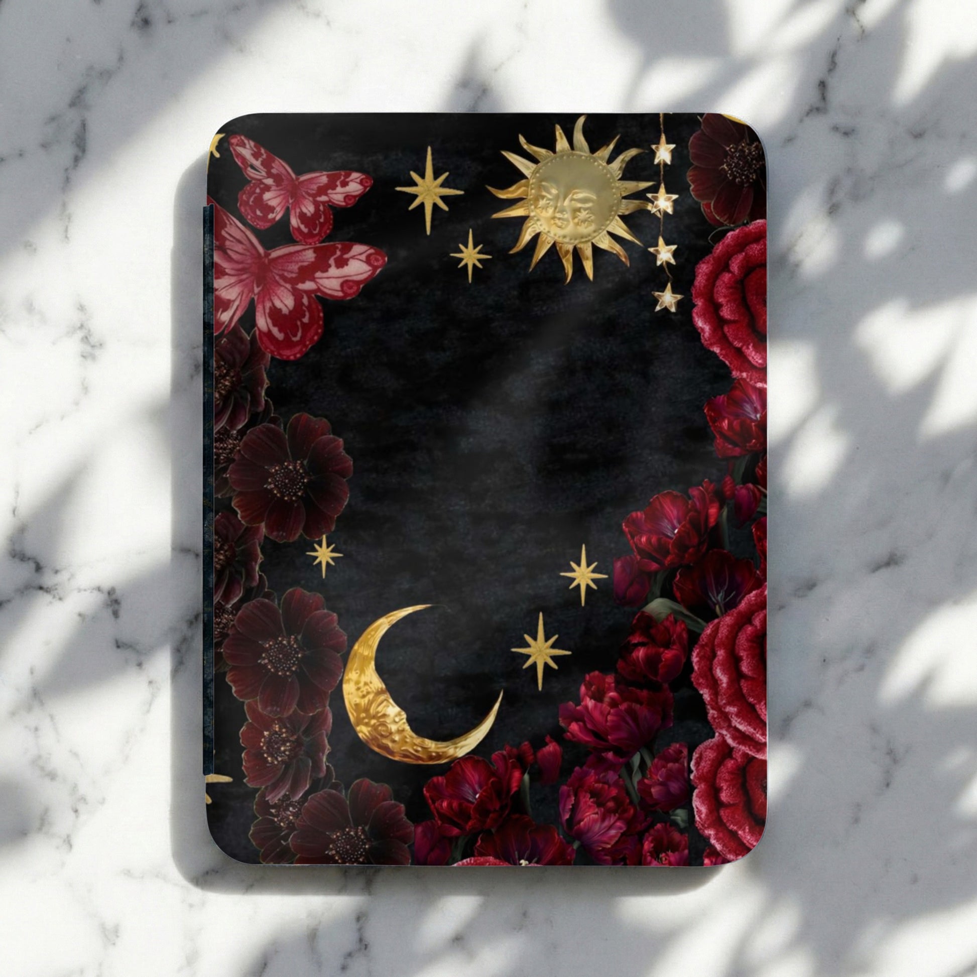 Dark floral design with butterflies, sun, moon, and stars on a textured background.