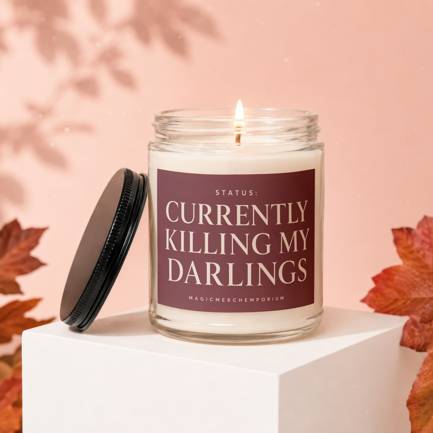 Candle with label "STATUS: CURRENTLY KILLING MY DARLINGS MAGICMERCHEMPORIUM"