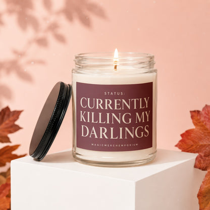 Candle with label "STATUS: CURRENTLY KILLING MY DARLINGS MAGICMERCHEMPORIUM"