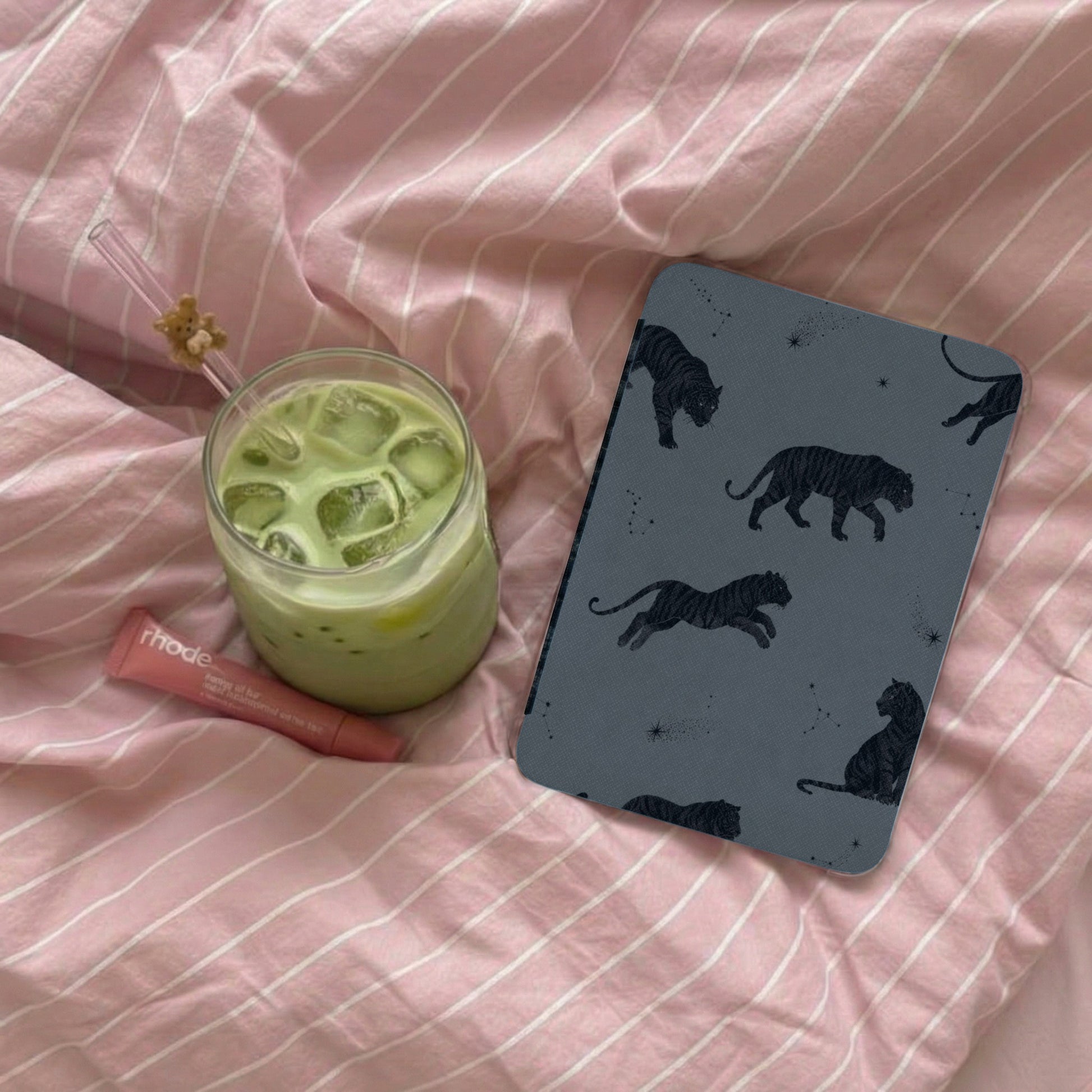 Gray case with black tiger pattern and constellations on pink striped fabric.
