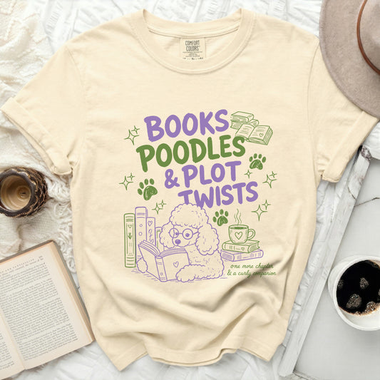 Cream t-shirt with purple and green design: "BOOKS POODLES & PLOT TWISTS".