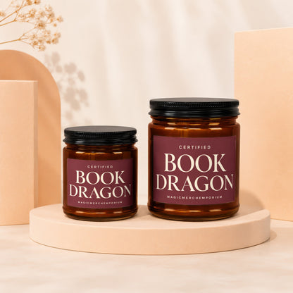 Amber jar candles with "Certified Book Dragon" labels on display stands.