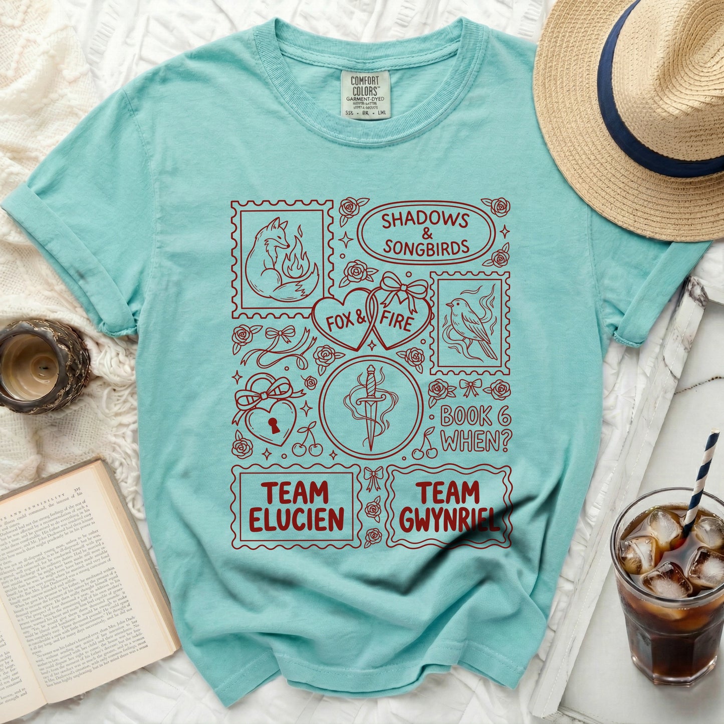 Teal t-shirt with "Shadows & Songbirds," "Fox & Fire," "Team Elucien," and "Team Gwynrie" graphics.