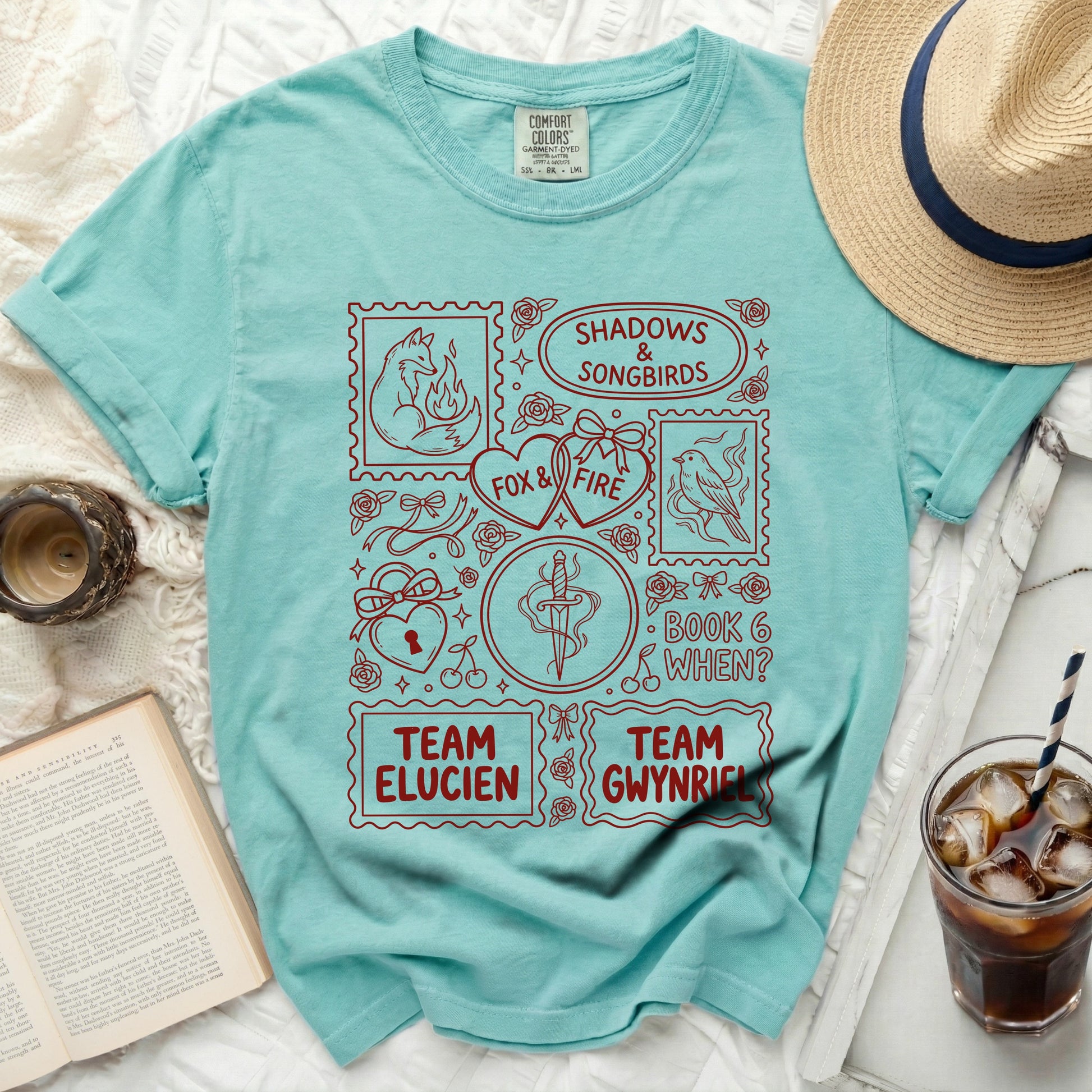 Teal t-shirt with "Shadows & Songbirds," "Fox & Fire," "Team Elucien," and "Team Gwynrie" graphics.