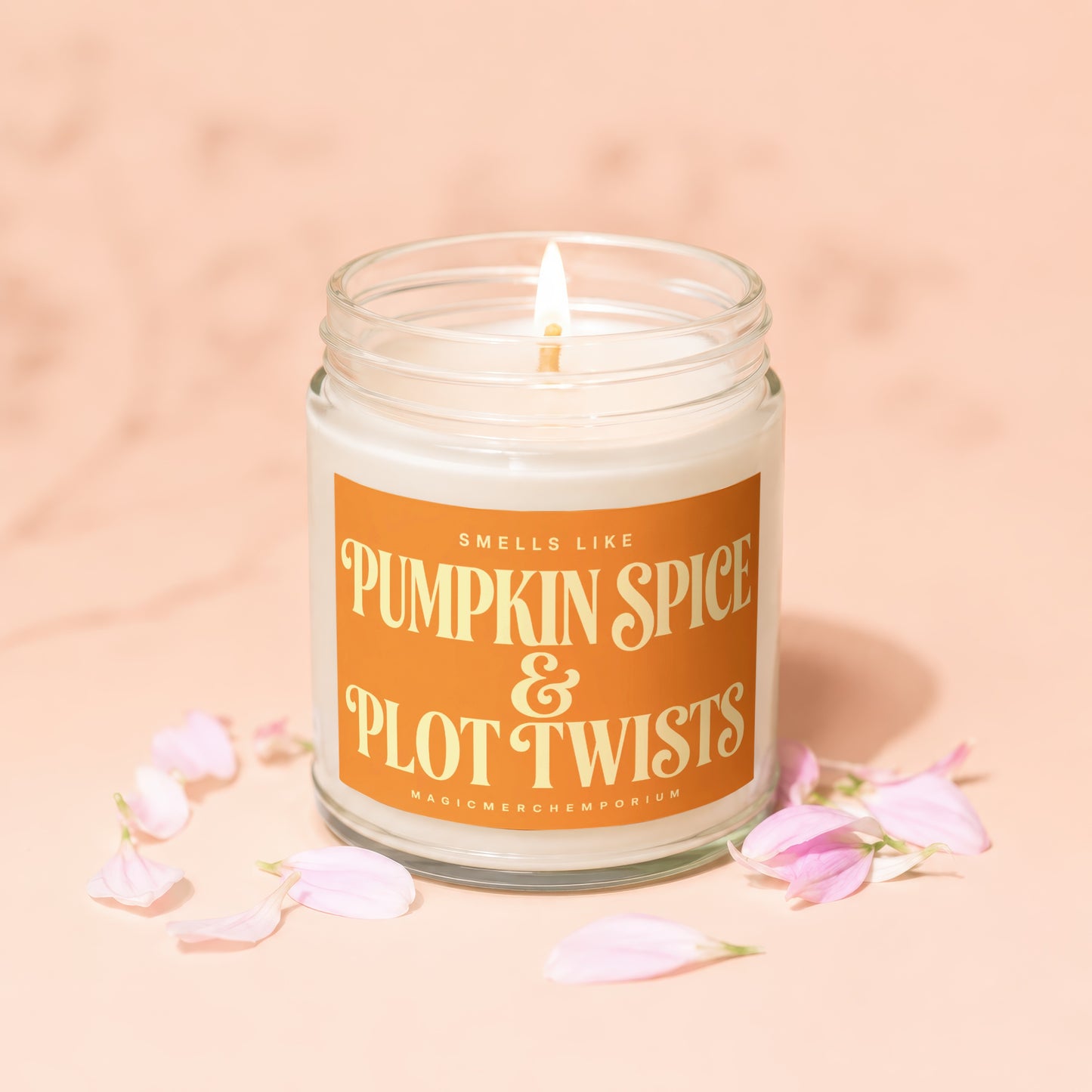 Lit candle in glass jar reading "Smells Like Pumpkin Spice & Plot Twists".