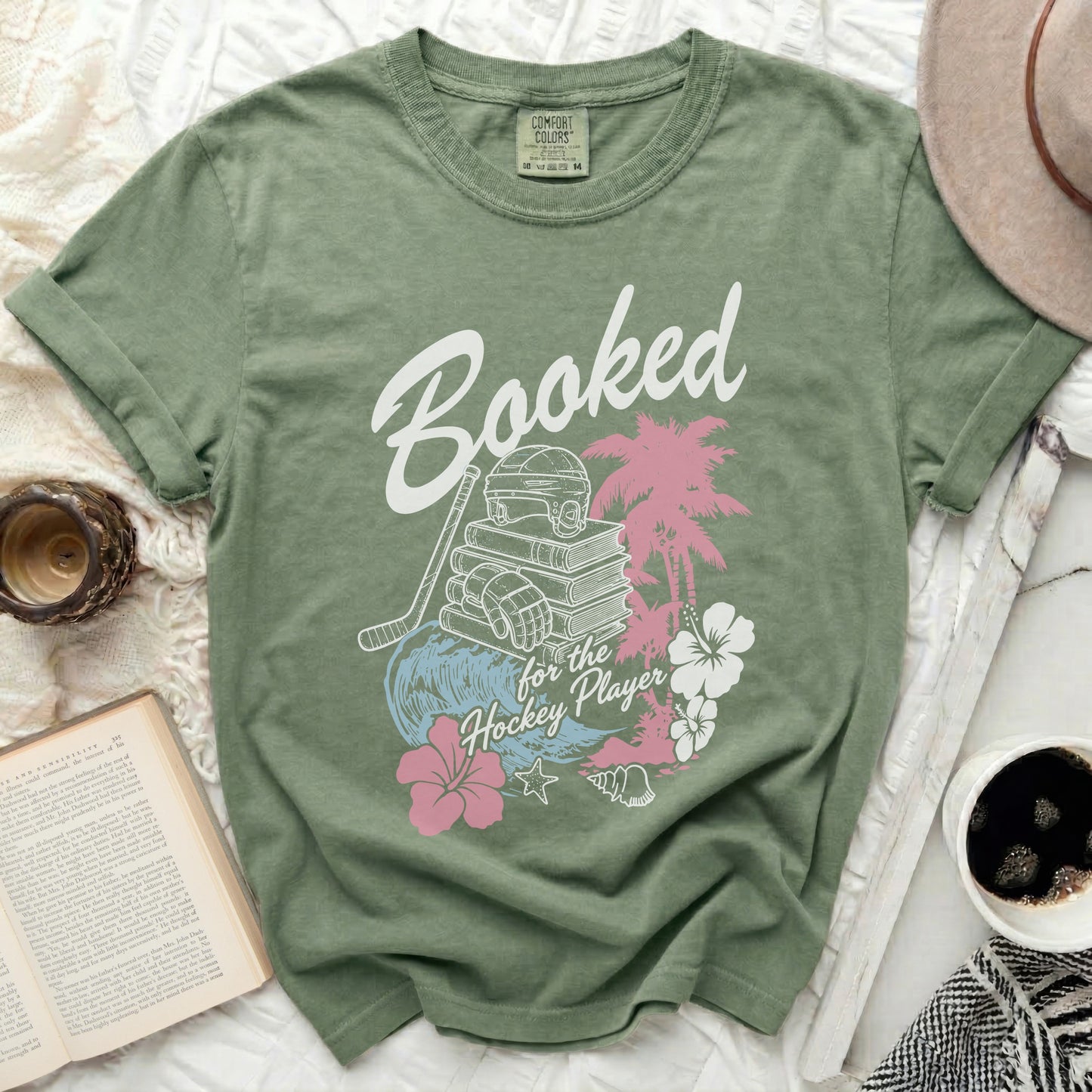 Green t-shirt with "Booked for the Hockey Player" text and hockey/tropical graphics.