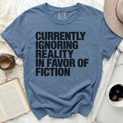 Blue t-shirt with "Currently Ignoring Reality In Favor Of Fiction" text.