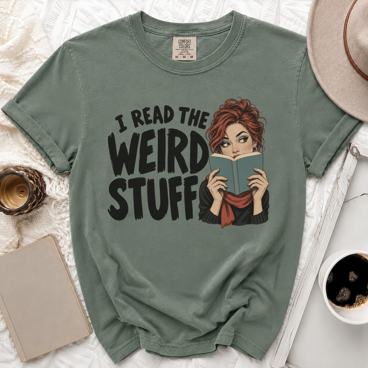 Green t-shirt with graphic text "I READ THE WEIRD STUFF" and a woman reading a book.