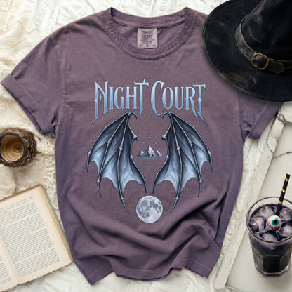 Purple t-shirt with "Night Court" text, bat wings, mountains, and moon graphic.