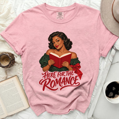 Pink t-shirt with a woman reading a book and the text "Here for the Romance".