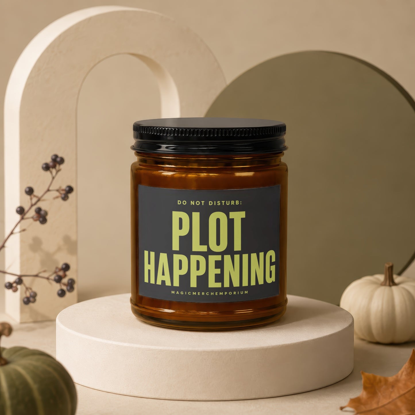 Amber jar candle with "PLOT HAPPENING" text on label, displayed with decorative pumpkins.