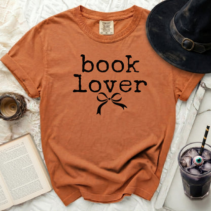 Orange t-shirt with black "book lover" text and bow.
