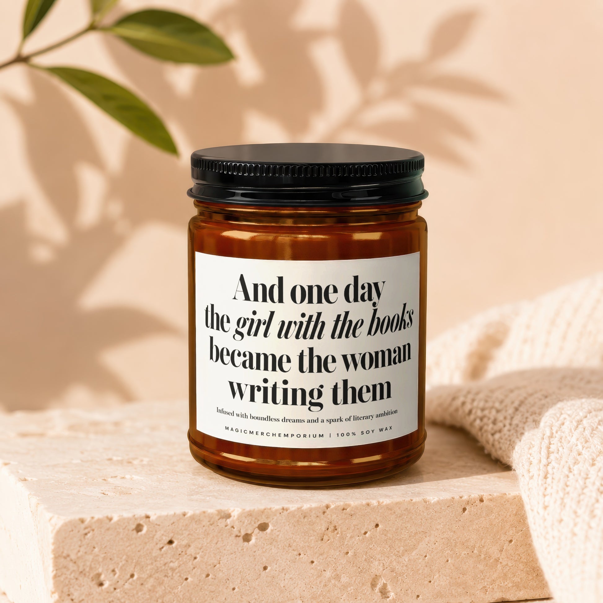 Amber jar candle with "And one day the girl with the books became the woman writing them" text.