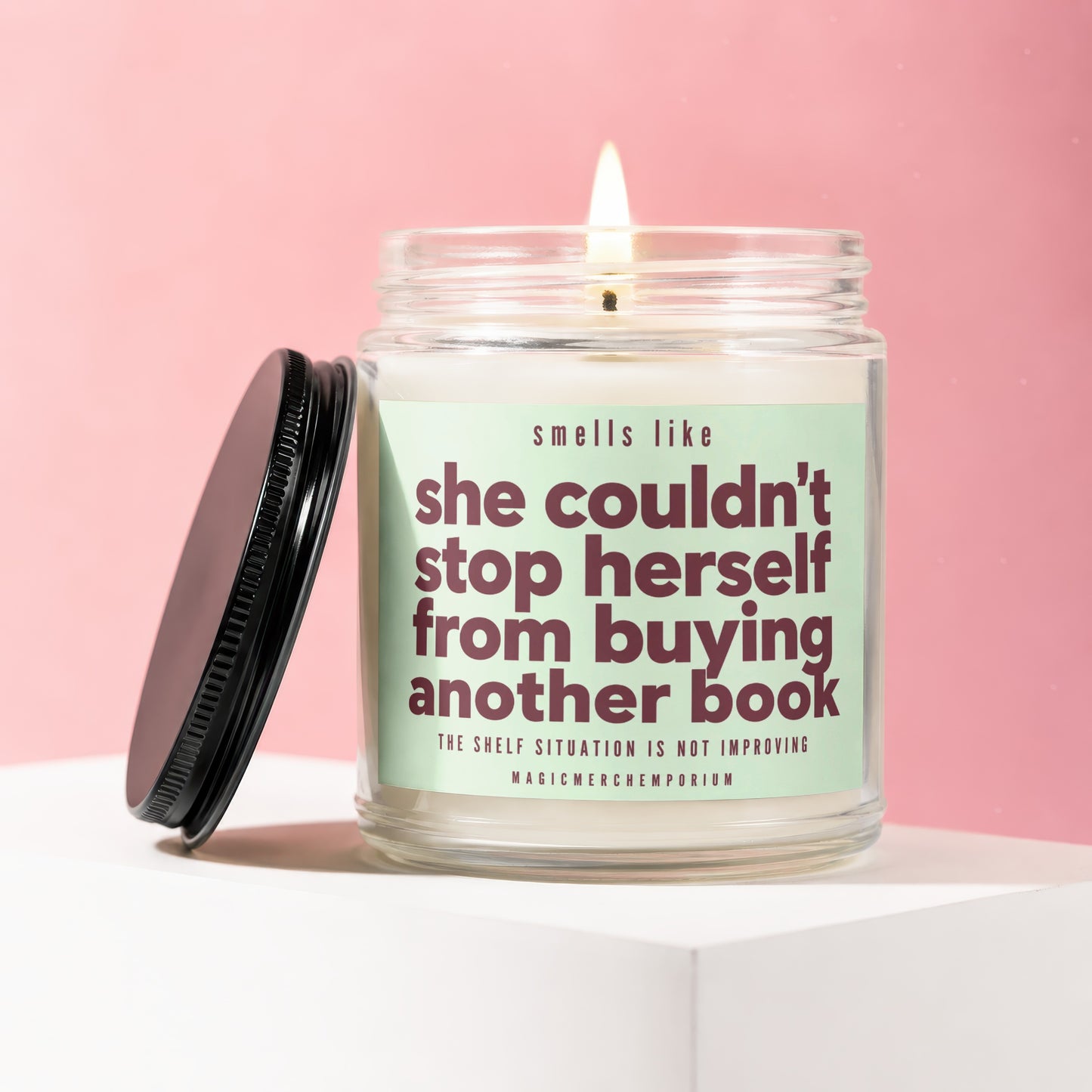 Jar candle with green label that says "she couldn't stop herself from buying another book."