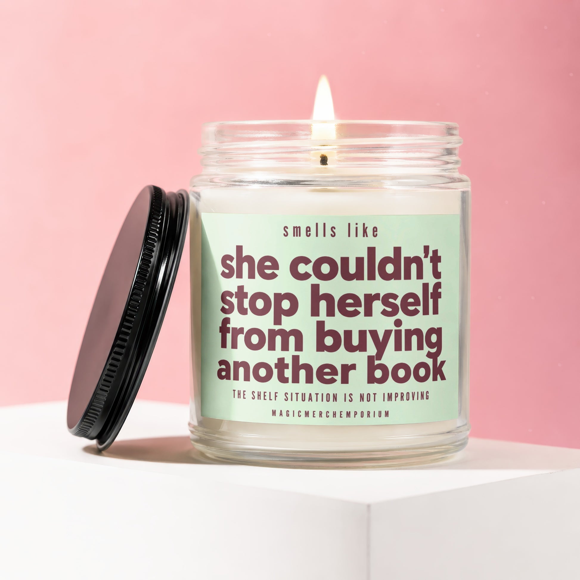 Jar candle with green label that says "she couldn't stop herself from buying another book."