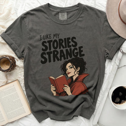 Dark grey Comfort Colors t-shirt with "I LIKE MY STORIES STRANGE" and a woman reading.