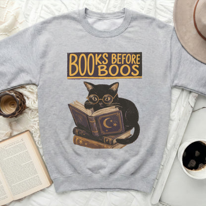 Grey sweatshirt with a black cat reading books and "Books Before Boos" text.
