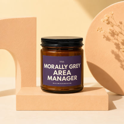 Candle with "Morally Grey Area Manager" text on purple label.
