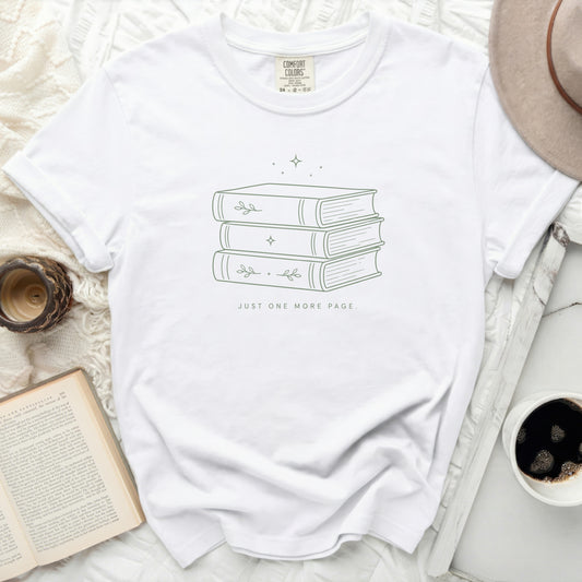 White t-shirt with minimalist stacked books and text "JUST ONE MORE PAGE."