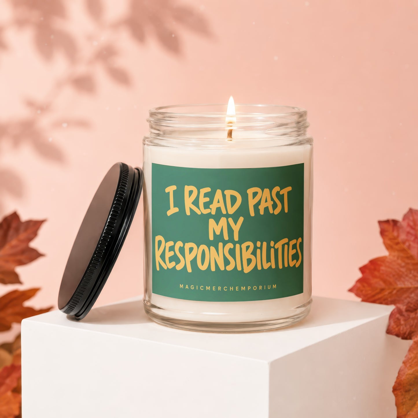 Glass candle with burning wick and lid off, saying "I READ PAST MY RESPONSIBILITIES".