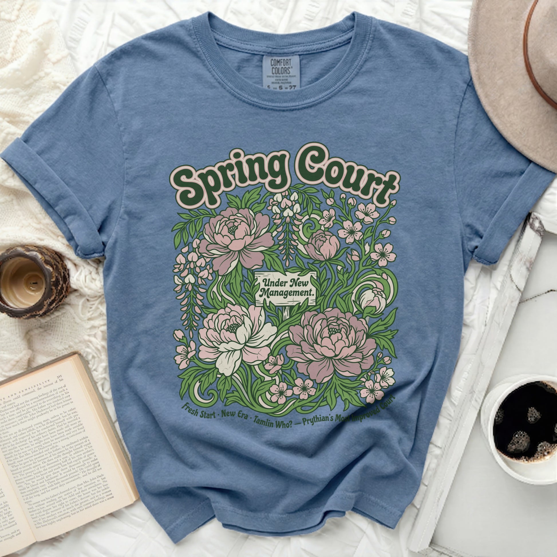 Blue t-shirt with "Spring Court Under New Management" and floral design.