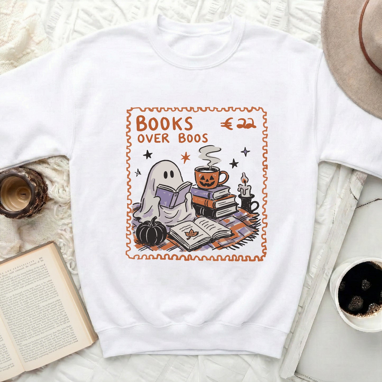 White sweatshirt with Halloween-themed graphic reading "Books Over Boos" around a ghost.
