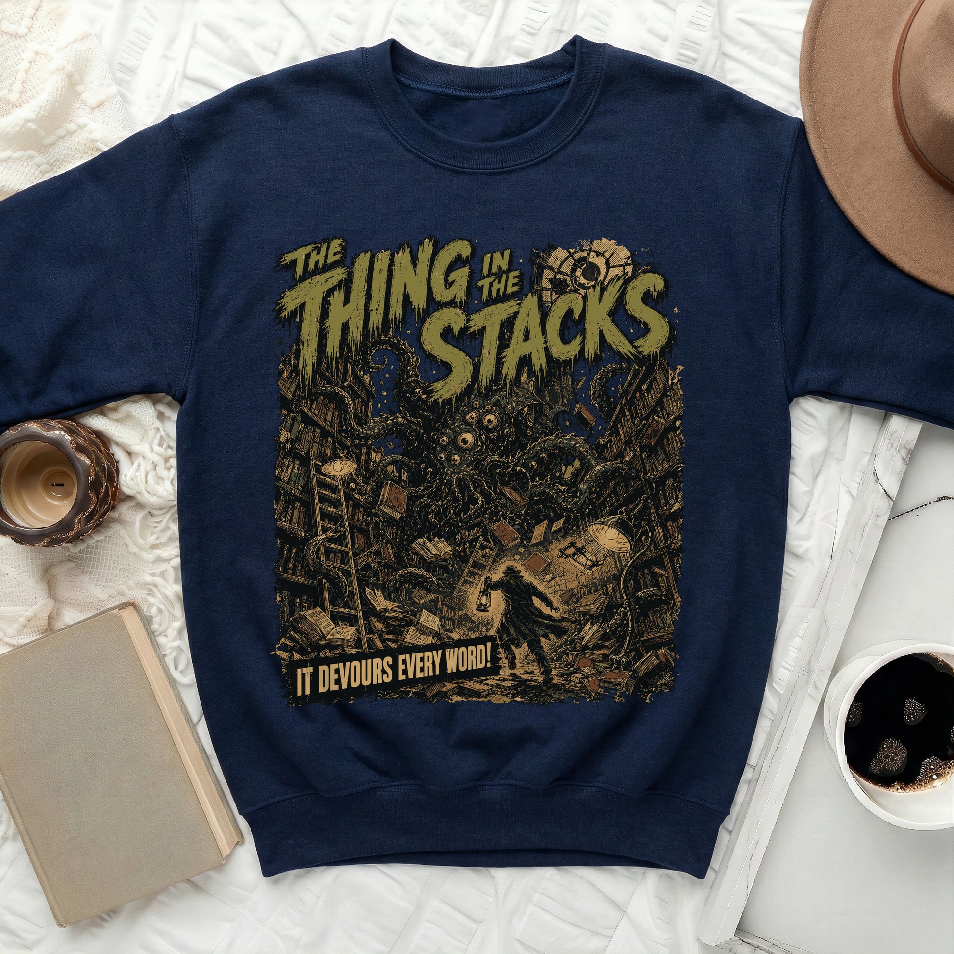 Navy sweatshirt with horror graphic featuring text "The Thing in the Stacks" and a creature.