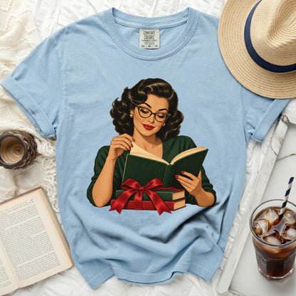 Light blue t-shirt with graphic of woman reading, holding books with red bow.
