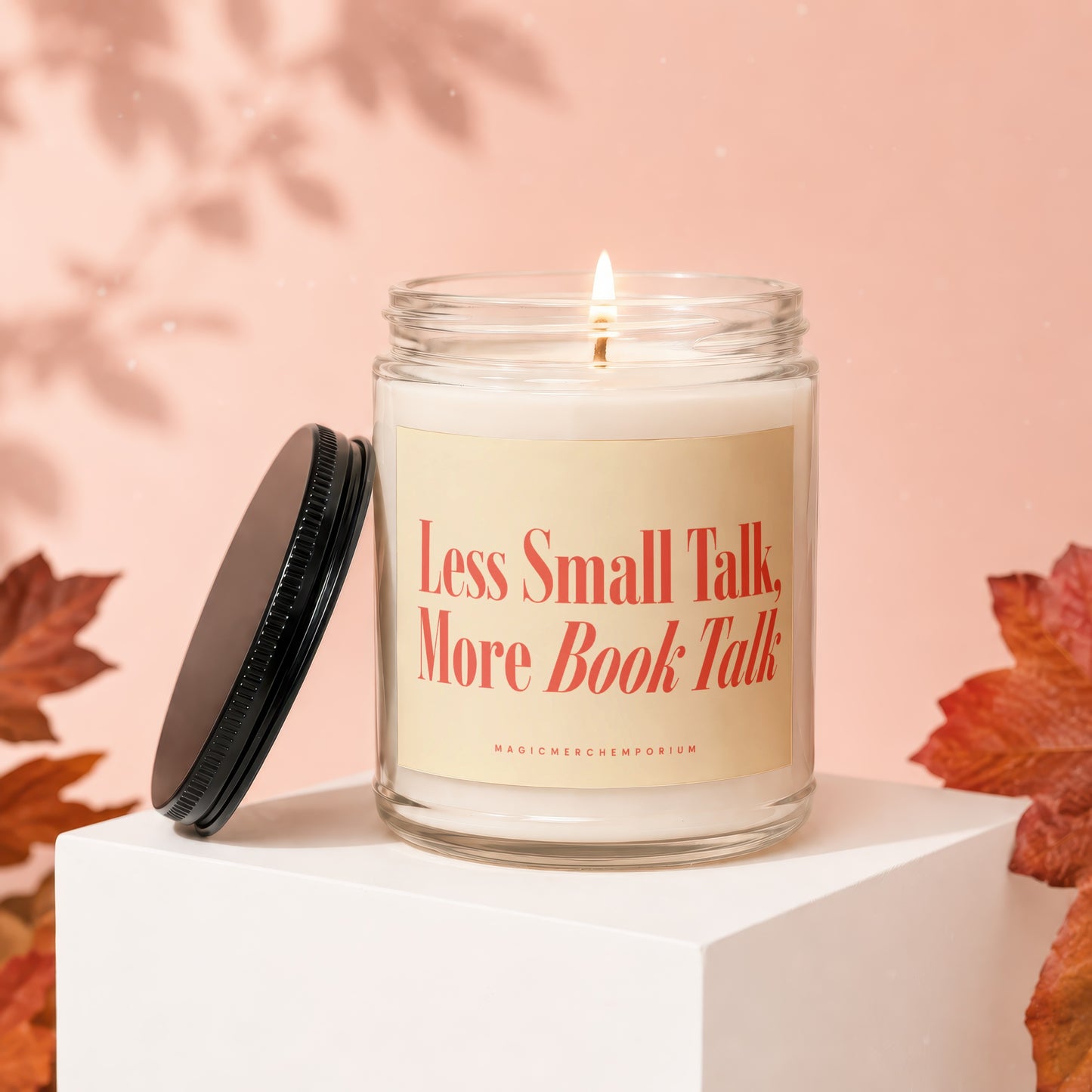 Glass candle with label "Less Small Talk, More Book Talk" on a pedestal.