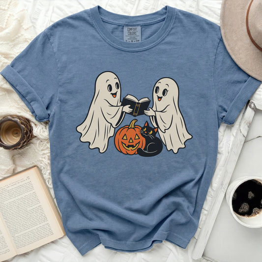 Two ghosts, a pumpkin, and a black cat reading a book, Halloween graphic.