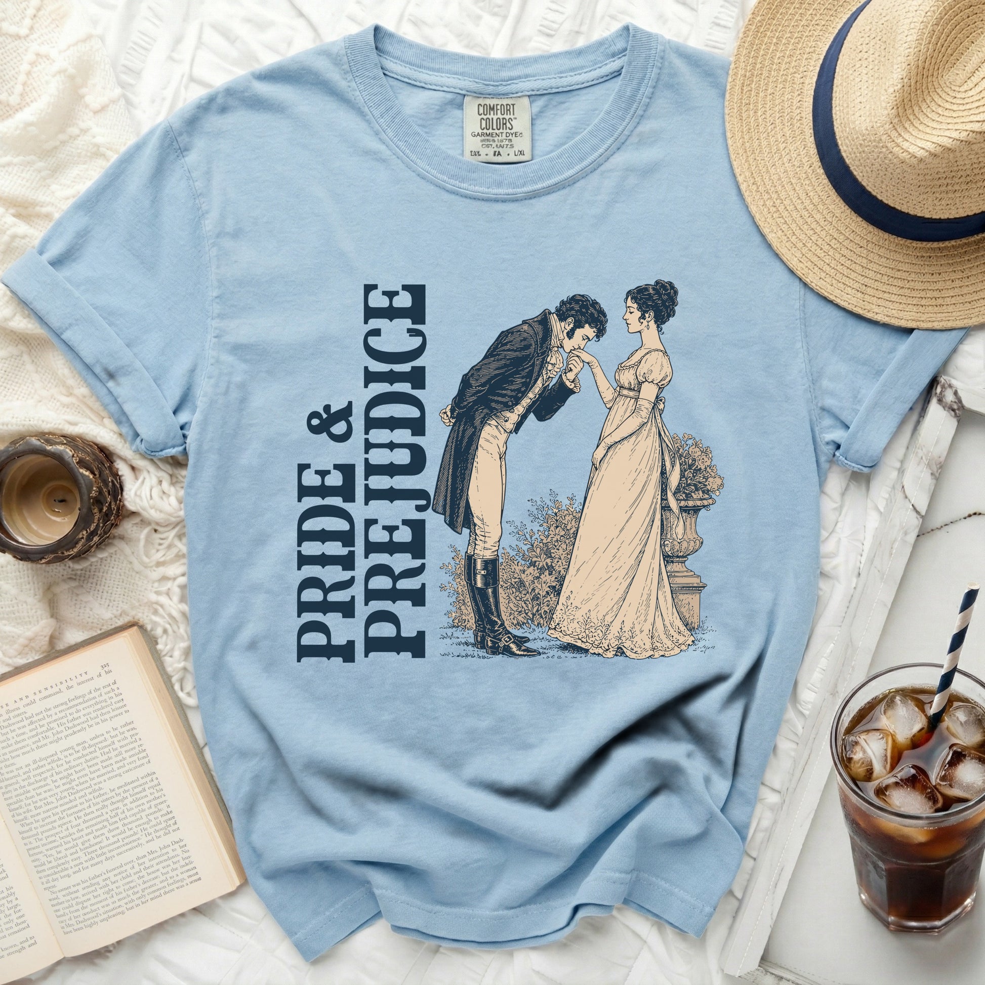 Light blue t-shirt with "Pride & Prejudice" text and illustration of a couple.