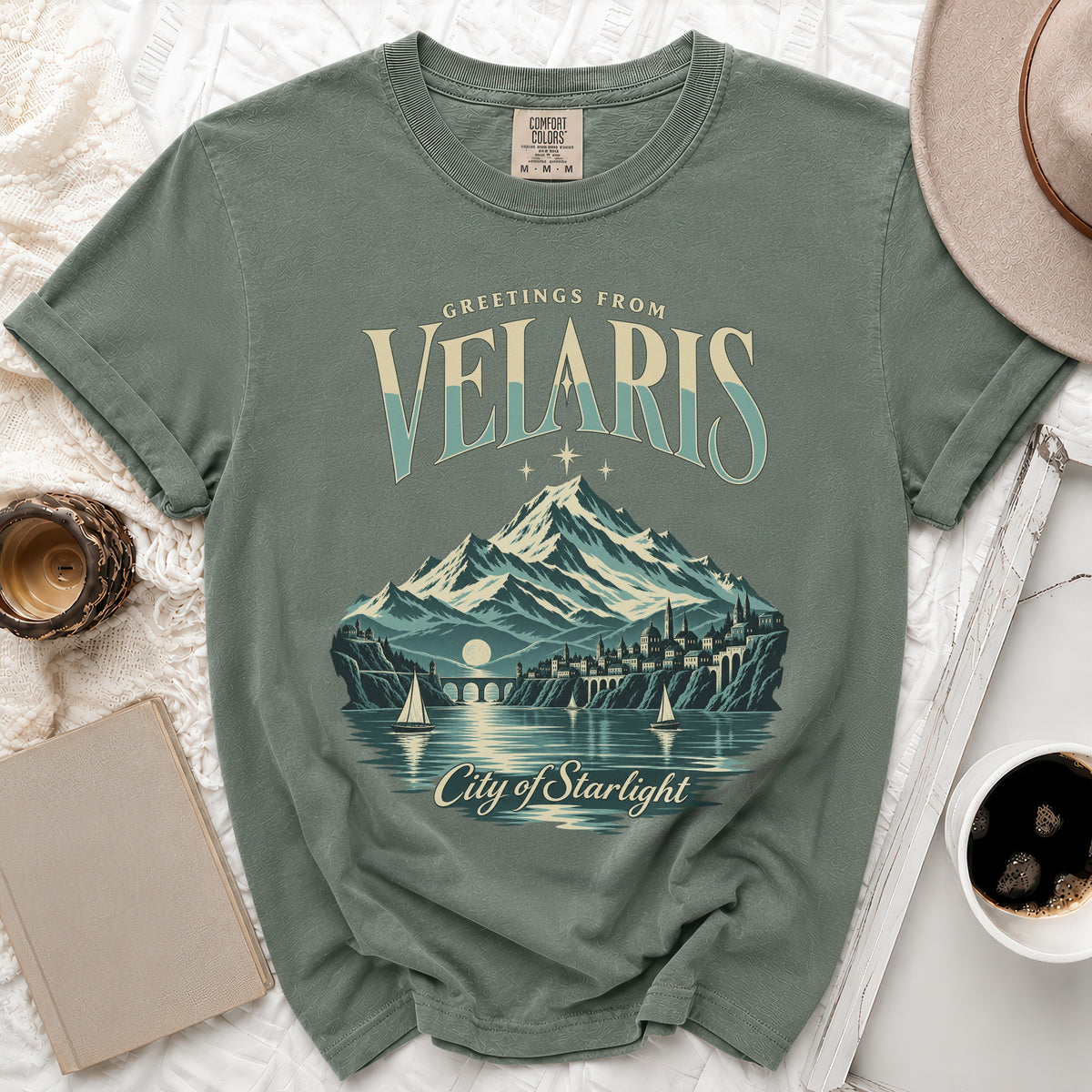 Green Comfort Colors t-shirt with Velaris City of Starlight graphic and mountains.