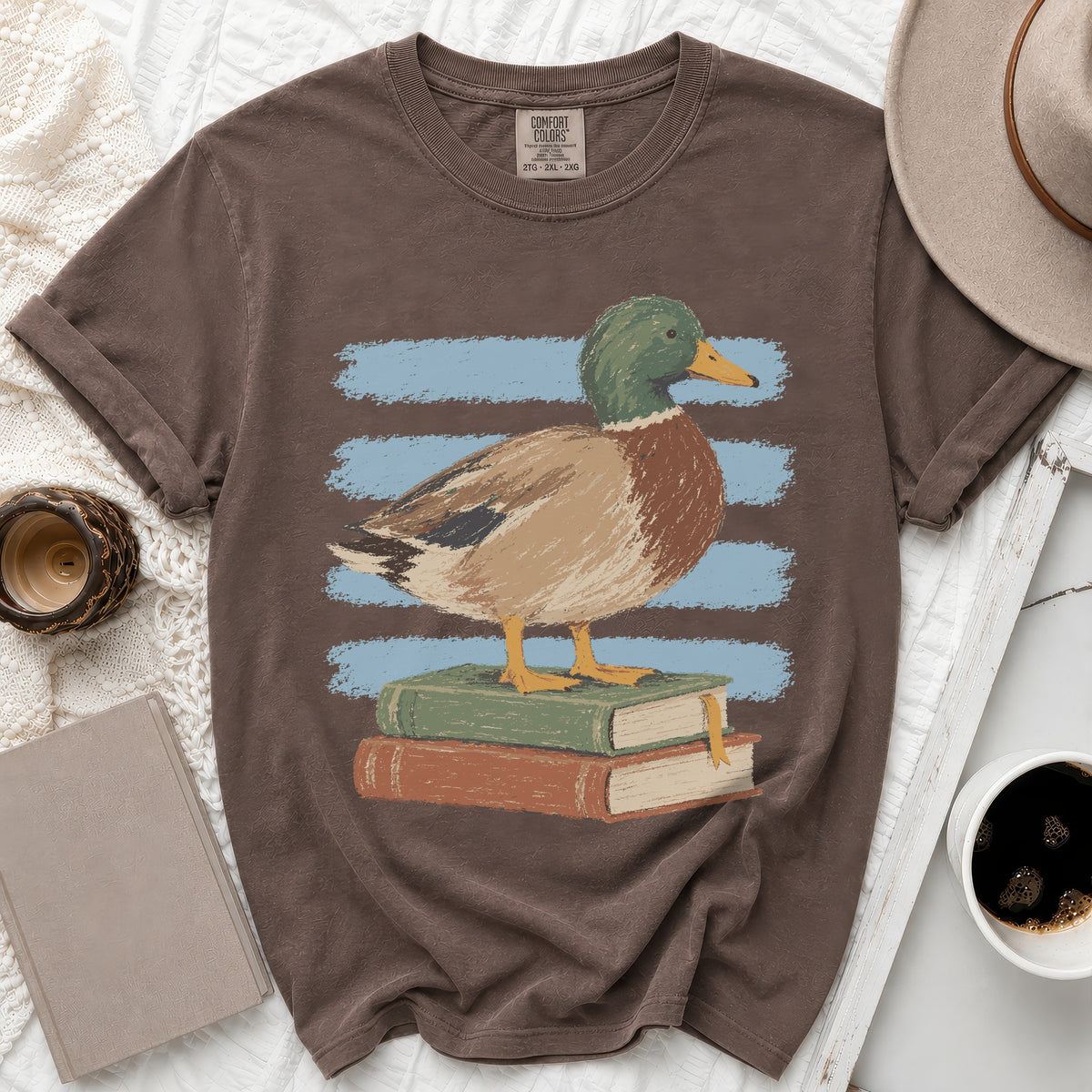 Brown t-shirt with a mallard duck standing on stacked books.