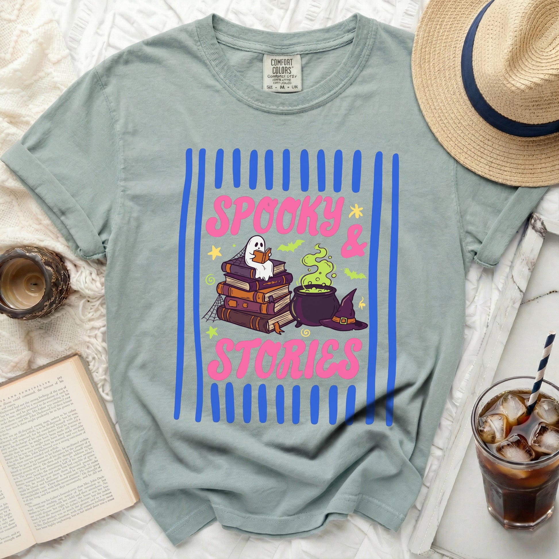 Green shirt with "Spooky & Stories" text, ghost, books, cauldron, and hat.