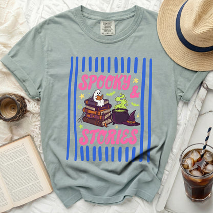 Green shirt with "Spooky & Stories" text, ghost, books, cauldron, and hat.