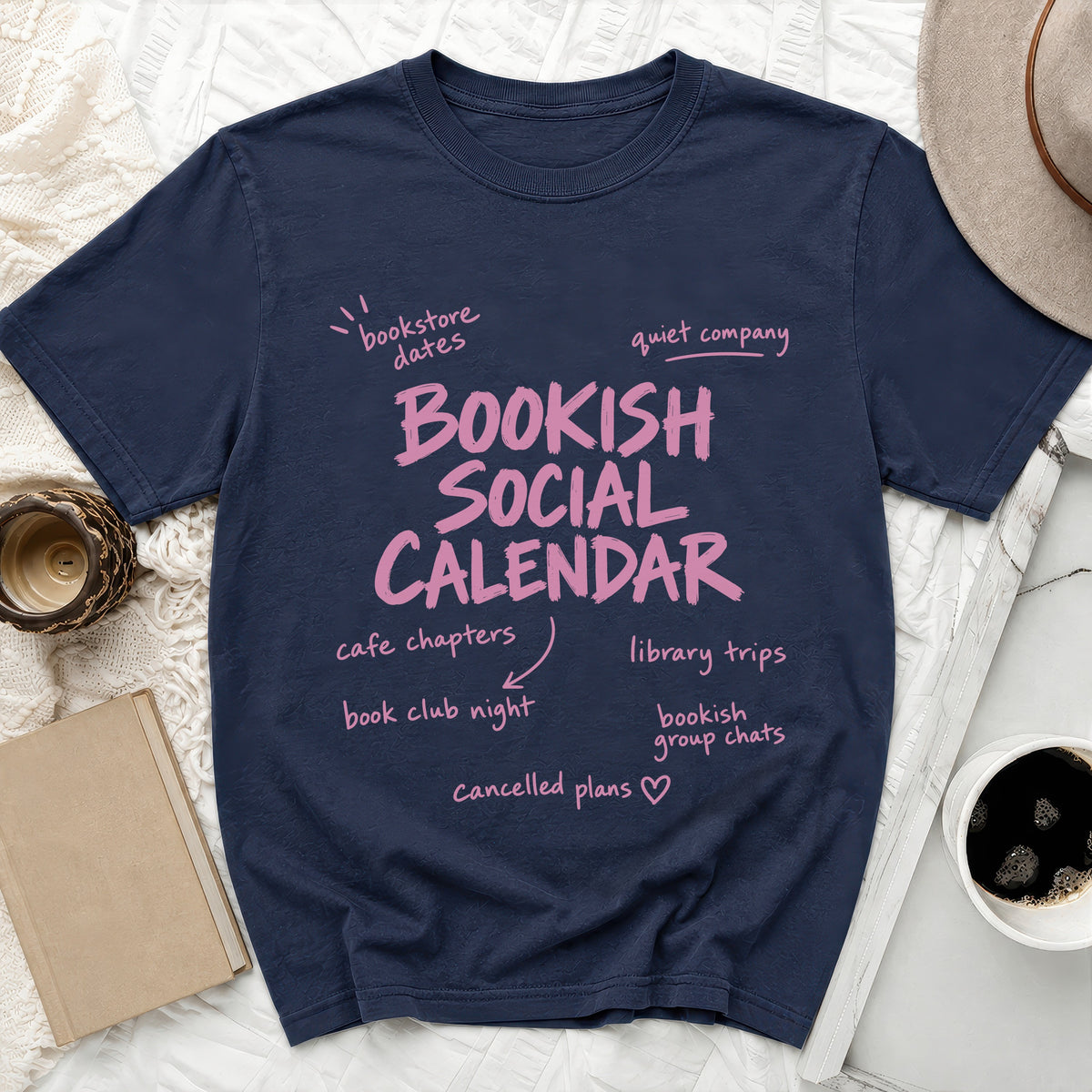 Navy t-shirt with pink text "BOOKISH SOCIAL CALENDAR" and related phrases.