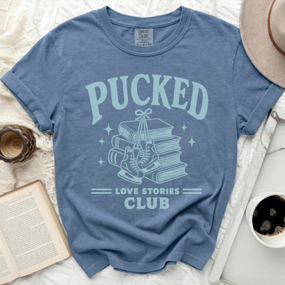 Blue t-shirt with "Pucked Love Stories Club" graphic on books and skates.