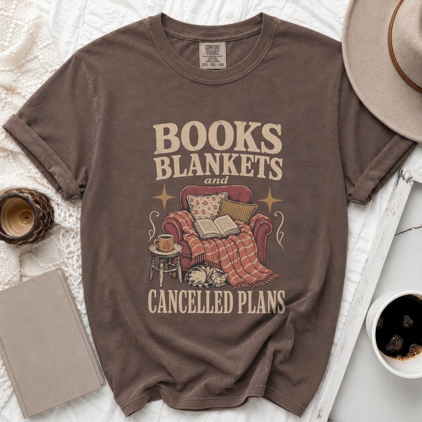 Brown t-shirt with "Books Blankets and Cancelled Plans" text and cozy scene.